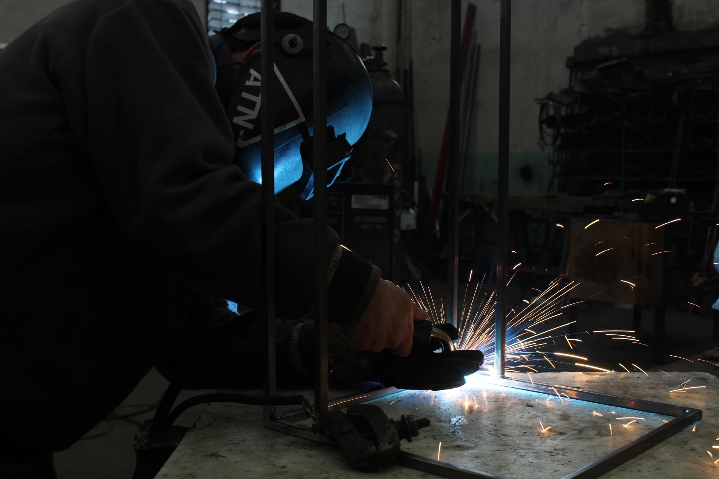 Corte con amoladora en el taller Guzmán, con chispas sobre una estructura en fabricación